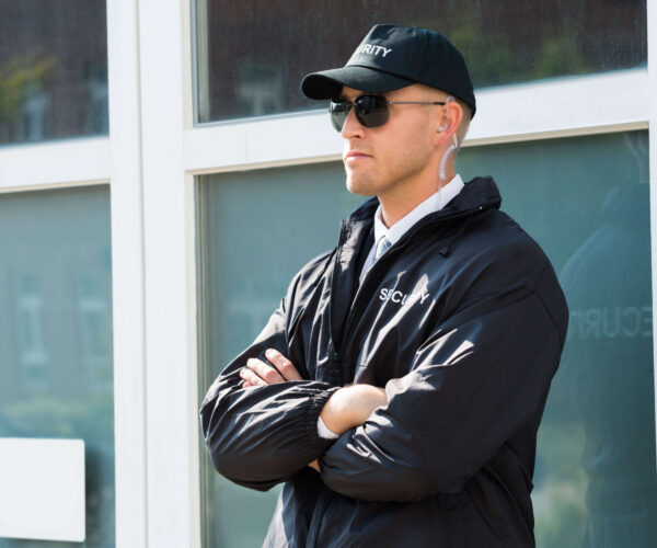 Young,Male,Security,Guard,Standing,At,The,Entrance